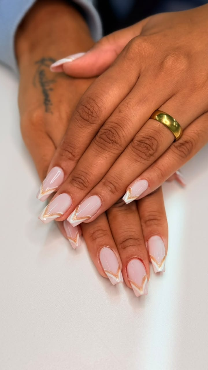 Unhas nude com francesinha branca diagonal e linhas douradas