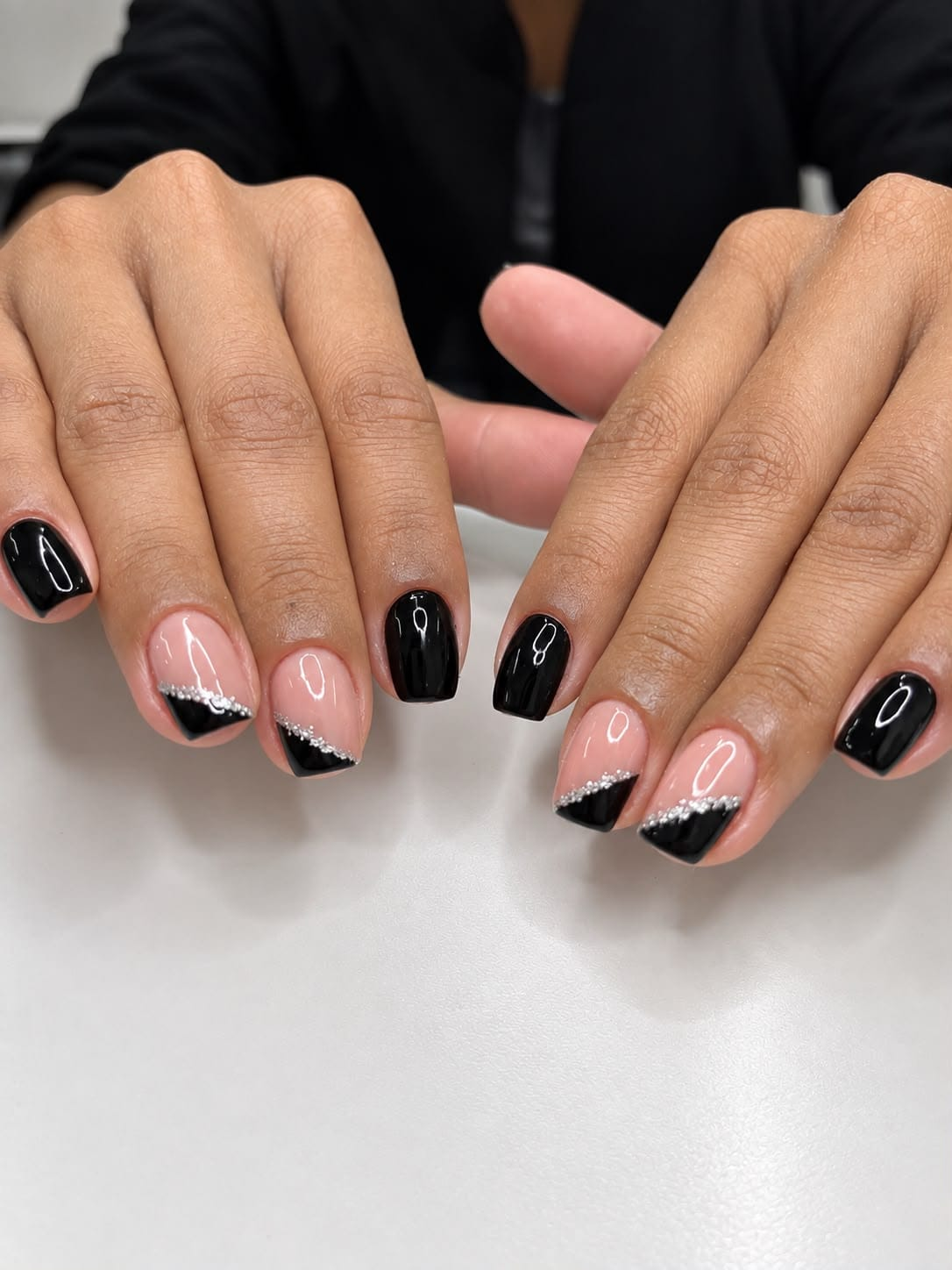 Unhas pretas e nude com francesinha diagonal e detalhes prateados